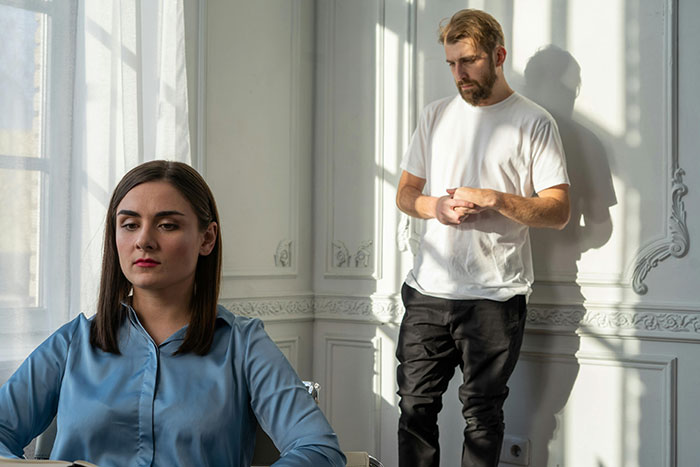 Woman in a blue shirt feeling trapped at home with her boyfriend challenging her medical expertise, in a sunlit room. Woman in a blue shirt feeling trapped at home with her boyfriend challenging her medical expertise, in a sunlit room.