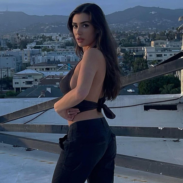 Bianca Censori poses on a rooftop at dusk, wearing a black halter top and jeans, creating a buzz after Kanye West split. Bianca Censori poses on a rooftop at dusk, wearing a black halter top and jeans, creating a buzz after Kanye West split.