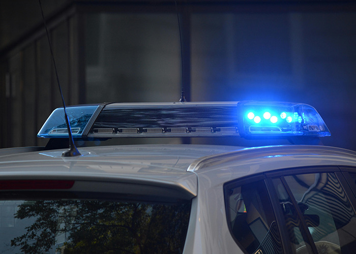 Police car with blue lights flashing at night, illustrating law enforcement vehicle. Police car with blue lights flashing at night, illustrating law enforcement vehicle.