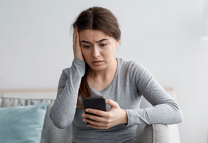 Woman looking shocked at a phone, discovering texts in an ER setting. Woman looking shocked at a phone, discovering texts in an ER setting.
