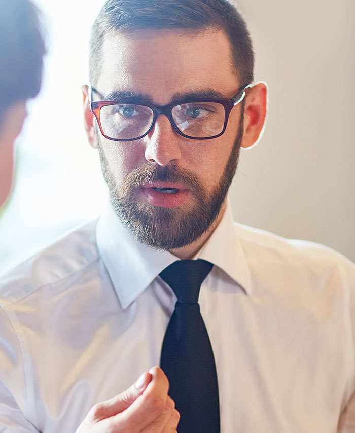 A man with glasses and a tie engaging in a business discussion, related to traders' arrogance and turning the tables. A man with glasses and a tie engaging in a business discussion, related to traders' arrogance and turning the tables.