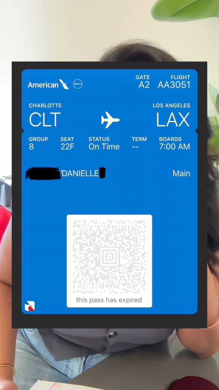 Airline boarding pass for a flight from Charlotte to Los Angeles displayed over a woman's torso. Airline boarding pass for a flight from Charlotte to Los Angeles displayed over a woman's torso.
