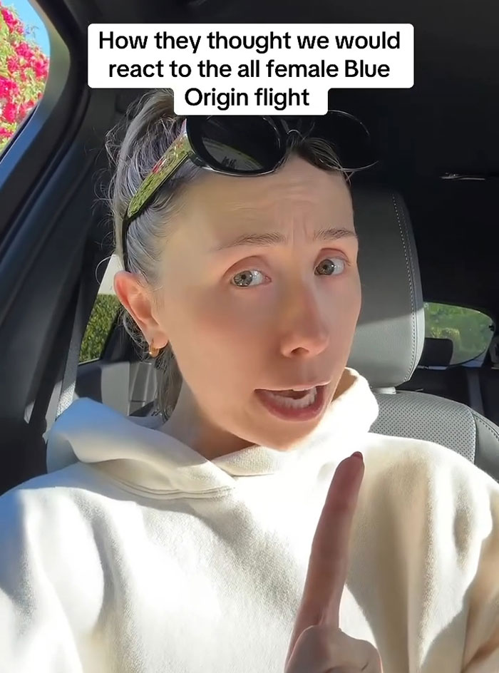 Person in car humorously mimicking public reaction to Blue Origin flight, emphasizing satire and comedy. Person in car humorously mimicking public reaction to Blue Origin flight, emphasizing satire and comedy.