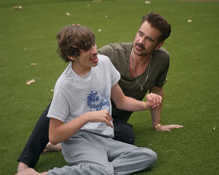 Father with his disabled son sitting on grass, sharing a moment outdoors. Father with his disabled son sitting on grass, sharing a moment outdoors.