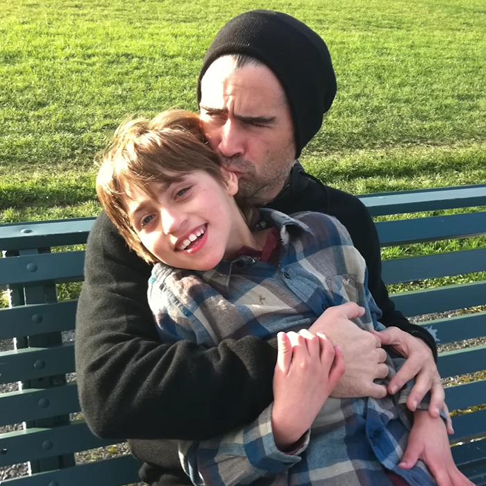 Father embracing son on a bench outdoors, displaying affection and care. Father embracing son on a bench outdoors, displaying affection and care.