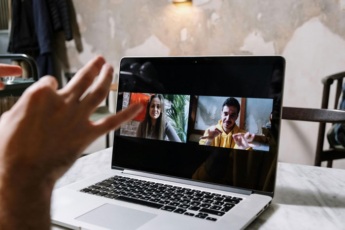Laptop showing a video call with coworkers, discussing a woman's attributes, causing her distress. Laptop showing a video call with coworkers, discussing a woman's attributes, causing her distress.