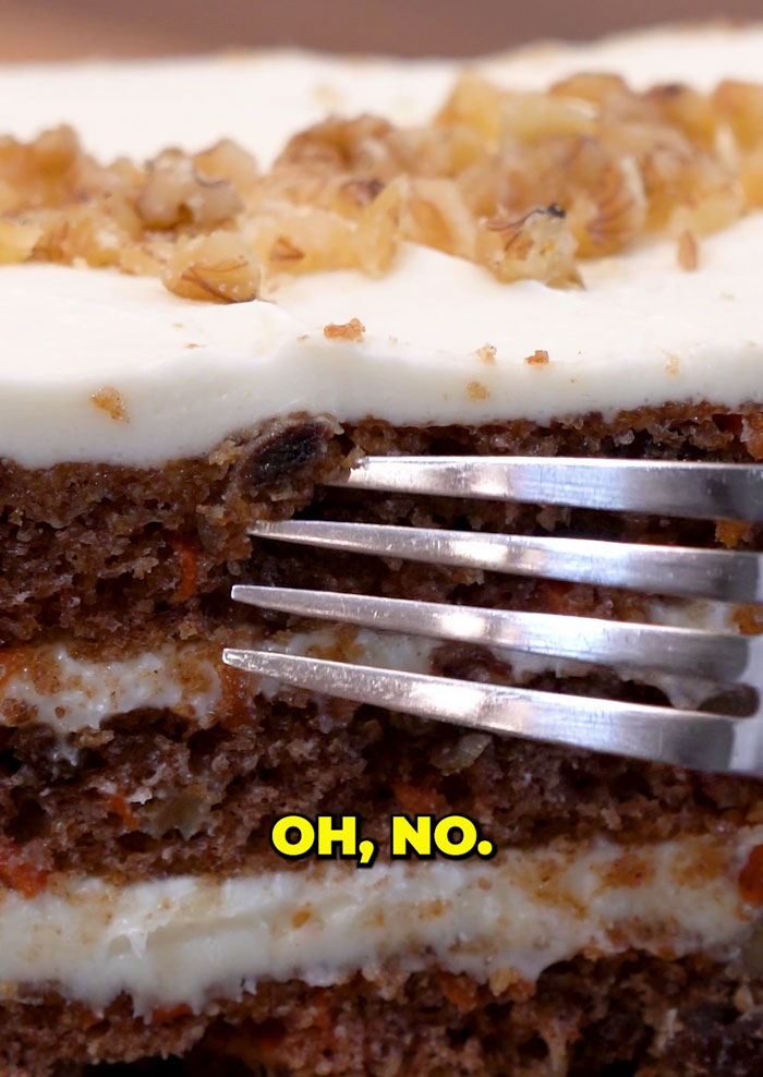 Close-up of a Costco carrot cake slice with fork, sparking debate on hidden ingredient. Close-up of a Costco carrot cake slice with fork, sparking debate on hidden ingredient.