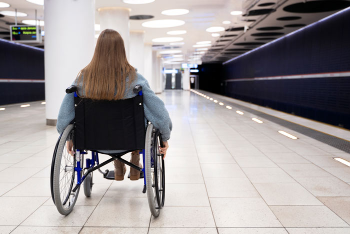 Person in wheelchair in an airport corridor, representing a scenario of seat rights for wheelchair users. Person in wheelchair in an airport corridor, representing a scenario of seat rights for wheelchair users.