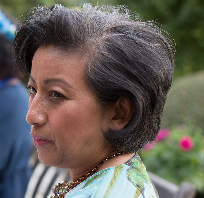 Woman seated outdoors, contemplating family inheritance issues. Woman seated outdoors, contemplating family inheritance issues.