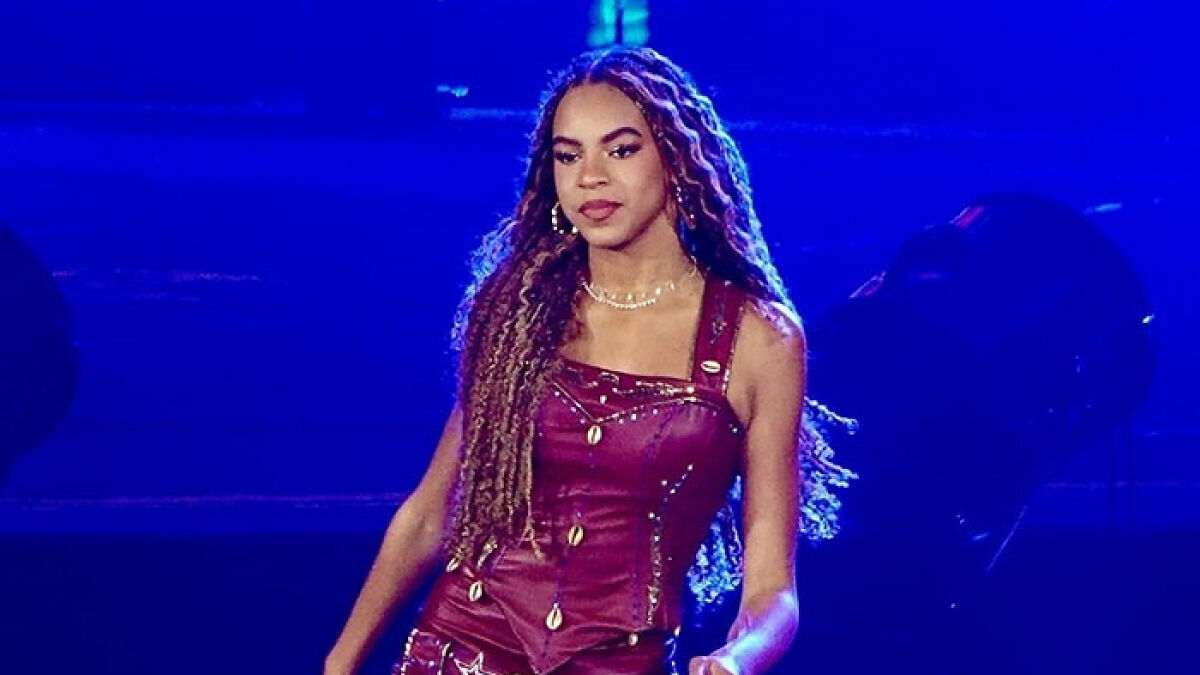 Blue Ivy performing live on stage, highlighted under blue lighting, linked to Beyoncu00e9 and Jay-Z grooming accusations.