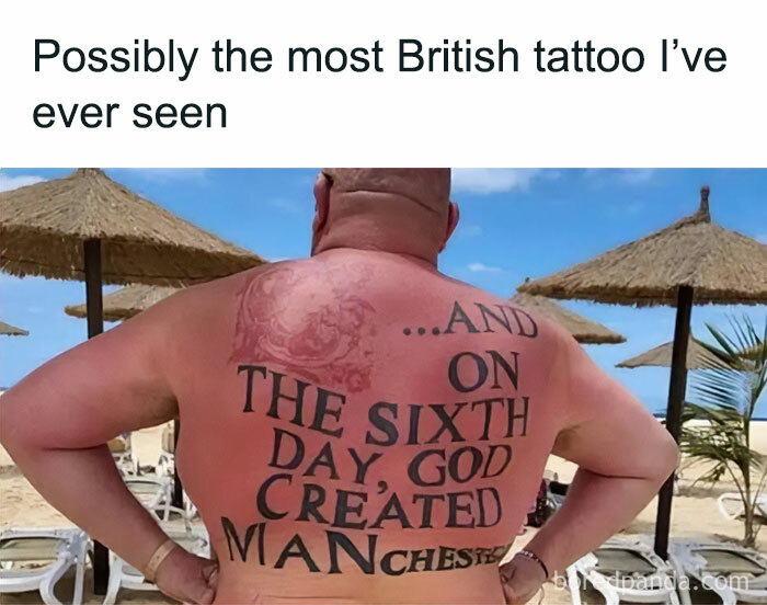 Back tattoo reading "On the sixth day, God created Manchester" on a beach, under straw umbrellas and blue sky.