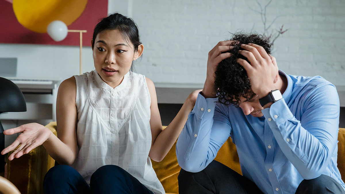Couple in a tense argument at home, highlighting a wife threatening divorce after dad defends bi daughter lifestyle.