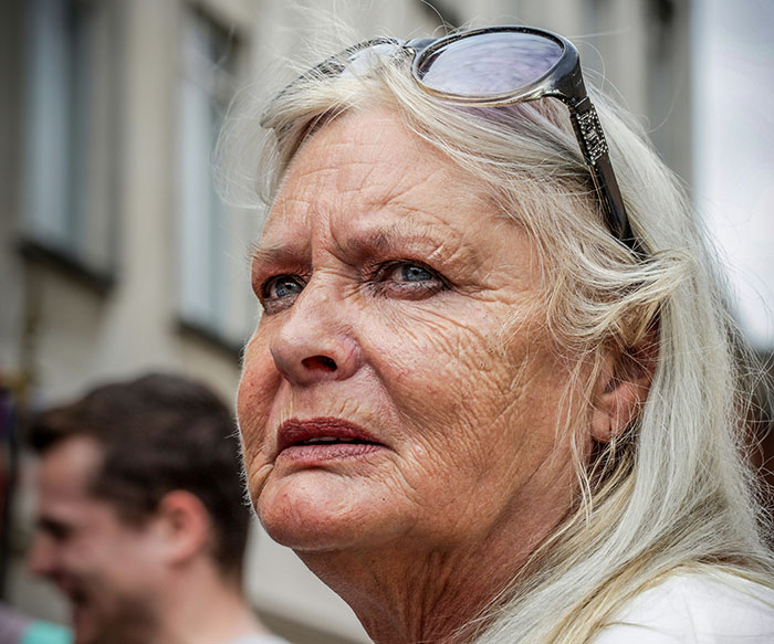 Elderly woman with long hair and sunglasses on her head, looking pensive outdoors on a sunny day. Elderly woman with long hair and sunglasses on her head, looking pensive outdoors on a sunny day.