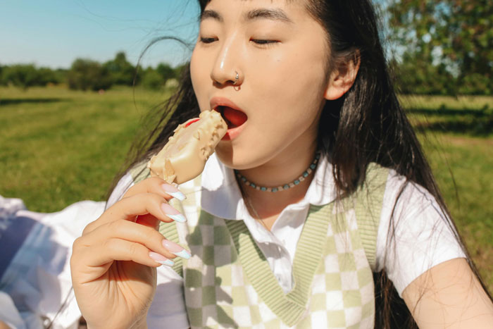 Girl enjoying ice cream outdoors, possibly reflecting a home life concern. Girl enjoying ice cream outdoors, possibly reflecting a home life concern.