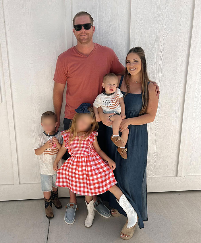 Family photo with parenting influencer and children, including 22-month-old son, standing against a white wall. Family photo with parenting influencer and children, including 22-month-old son, standing against a white wall.