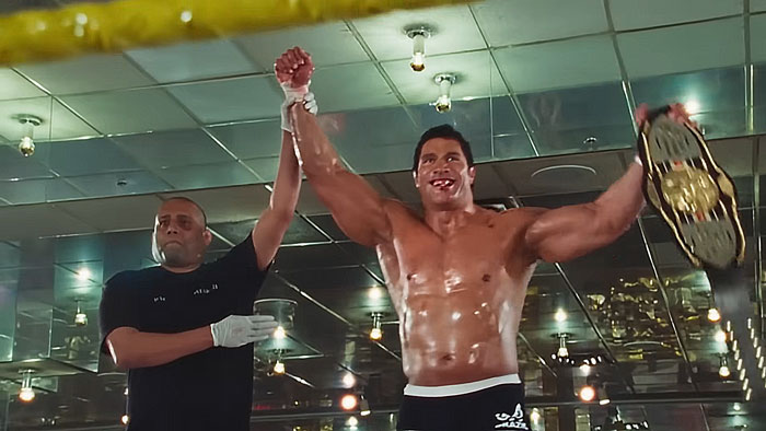 Dwayne Johnson showing his impressive transformation, shirtless and holding a wrestling championship belt in a celebratory pose. Dwayne Johnson showing his impressive transformation, shirtless and holding a wrestling championship belt in a celebratory pose.