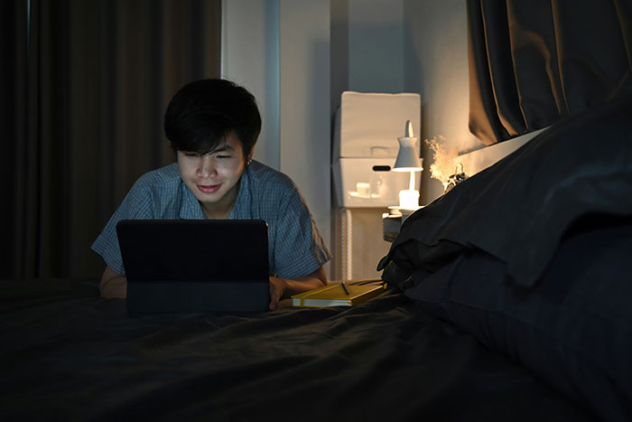 Person in dimly lit room, looking at a tablet, reflects tension and intrigue around partner plots. Person in dimly lit room, looking at a tablet, reflects tension and intrigue around partner plots.