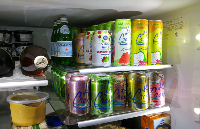 A fridge stocked with various sparkling water cans and bottles, featuring brands like LaCroix and S.Pellegrino. A fridge stocked with various sparkling water cans and bottles, featuring brands like LaCroix and S.Pellegrino.