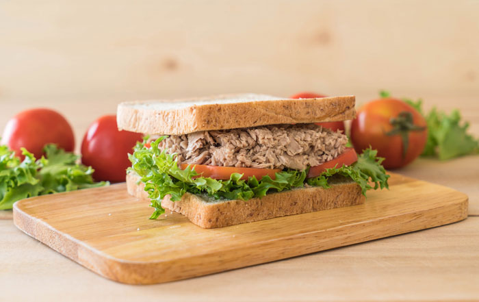 Tuna sandwich on a wooden board with lettuce and tomatoes, related to reconsidering relationships. Tuna sandwich on a wooden board with lettuce and tomatoes, related to reconsidering relationships.
