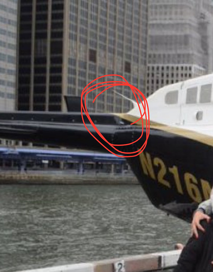 Helicopter detail with red circle before crash over water, suggesting possible cause. Helicopter detail with red circle before crash over water, suggesting possible cause.