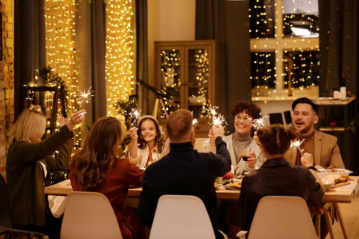 Group of friends celebrating at a festively decorated table with sparklers, related to concerns about a financial situation. Group of friends celebrating at a festively decorated table with sparklers, related to concerns about a financial situation.