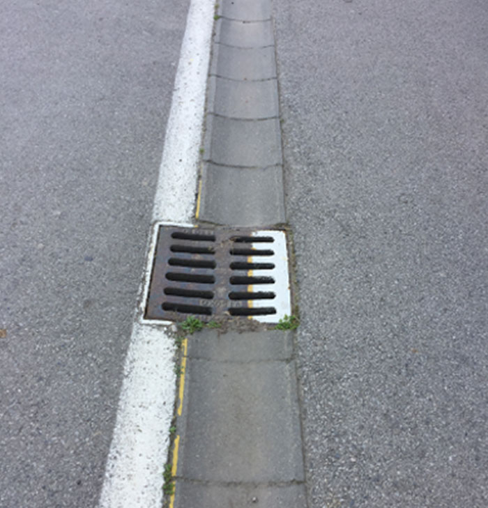 Misaligned street drain showing a repair fail.
