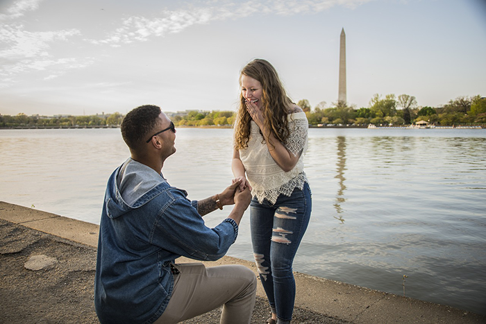 Man proposing to woman by a waterfront, facing inheritance debate over biological kids. Washington Monument in the background. Man proposing to woman by a waterfront, facing inheritance debate over biological kids. Washington Monument in the background.