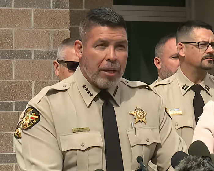Sheriff in uniform addressing media about Gene Hackman's notes at a press conference outdoors. Sheriff in uniform addressing media about Gene Hackman's notes at a press conference outdoors.