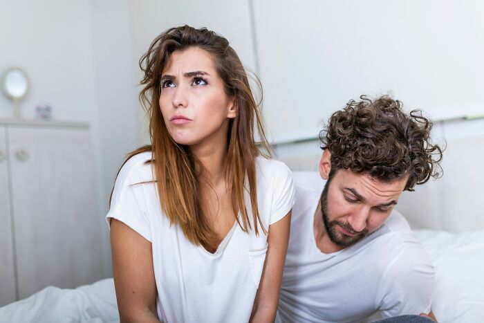 Couple in bed looking upset, illustrating emotions behind why some guys slept with a married woman in a tense moment.