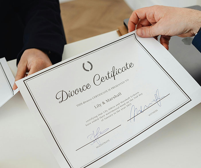 Hands holding a divorce certificate, symbolizing family breakup and bond challenges. Hands holding a divorce certificate, symbolizing family breakup and bond challenges.