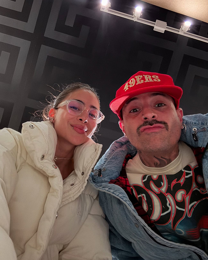 Two people pose playfully for a selfie, one wearing glasses and a jacket, the other in a red cap. Two people pose playfully for a selfie, one wearing glasses and a jacket, the other in a red cap.