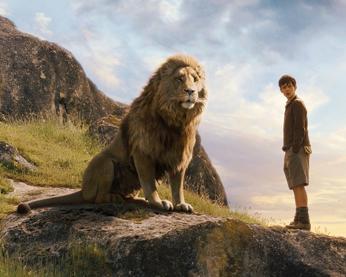 Scene from Narnia reboot with a lion and a boy on a rocky hill under a cloudy sky. Scene from Narnia reboot with a lion and a boy on a rocky hill under a cloudy sky.