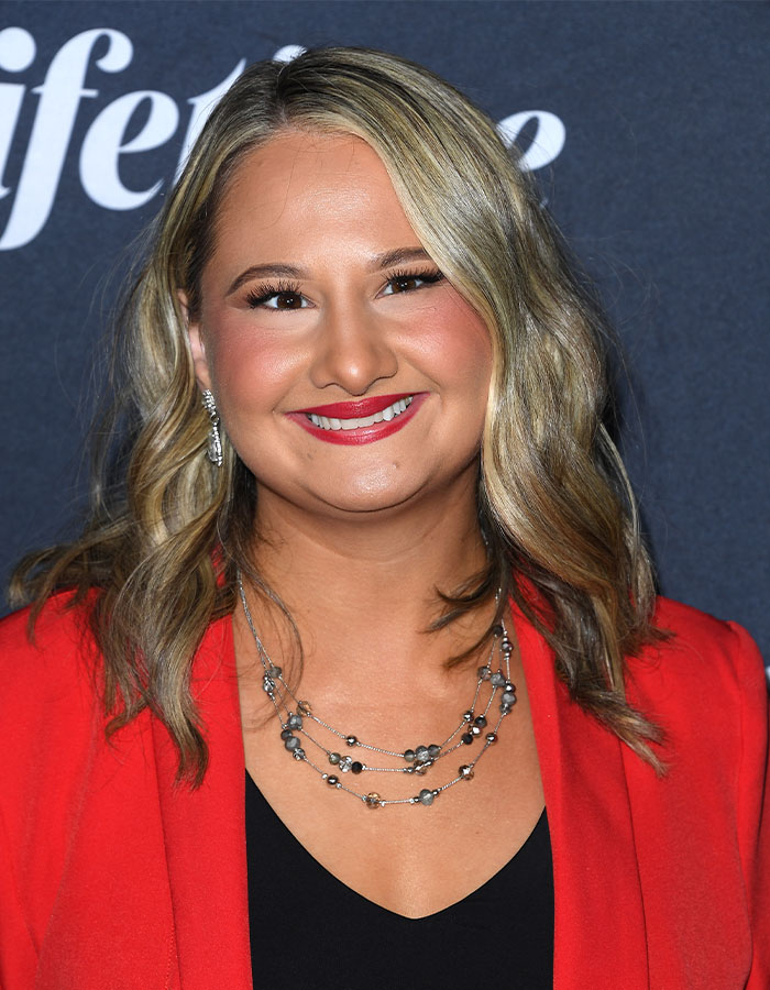 A woman with blonde hair in a red blazer, smiling, related to Gypsy-Rose Blanchard and weight loss transformation. A woman with blonde hair in a red blazer, smiling, related to Gypsy-Rose Blanchard and weight loss transformation.