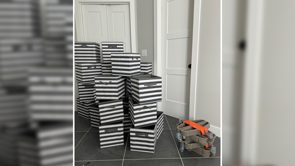 Stacked black and white striped storage boxes and gray furniture leg protectors on a tiled floor in a home.