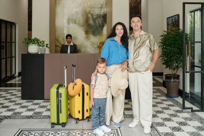 Family ready for vacation with luggage in hotel lobby, mom excited and nervous. Family ready for vacation with luggage in hotel lobby, mom excited and nervous.