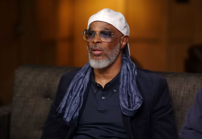 Film legend discusses personal love story, wearing a white hat and glasses in an interview setting. Film legend discusses personal love story, wearing a white hat and glasses in an interview setting.