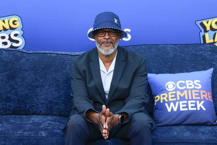 Film legend at CBS Premiere Week event, wearing a bucket hat and glasses, seated on a blue couch. Film legend at CBS Premiere Week event, wearing a bucket hat and glasses, seated on a blue couch.