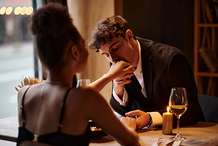 Couple sharing a romantic late-night drink as husband enjoys time with coworker in intimate restaurant setting. Couple sharing a romantic late-night drink as husband enjoys time with coworker in intimate restaurant setting.