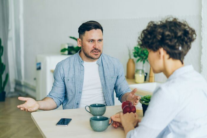 Man and woman discussing mortgage and holiday costs at a kitchen table. Man and woman discussing mortgage and holiday costs at a kitchen table.