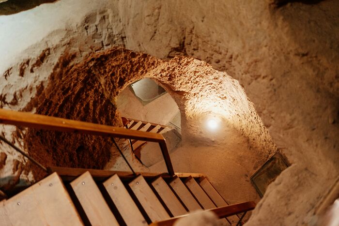 Wooden stairs leading into an eerie underground city tunnel.