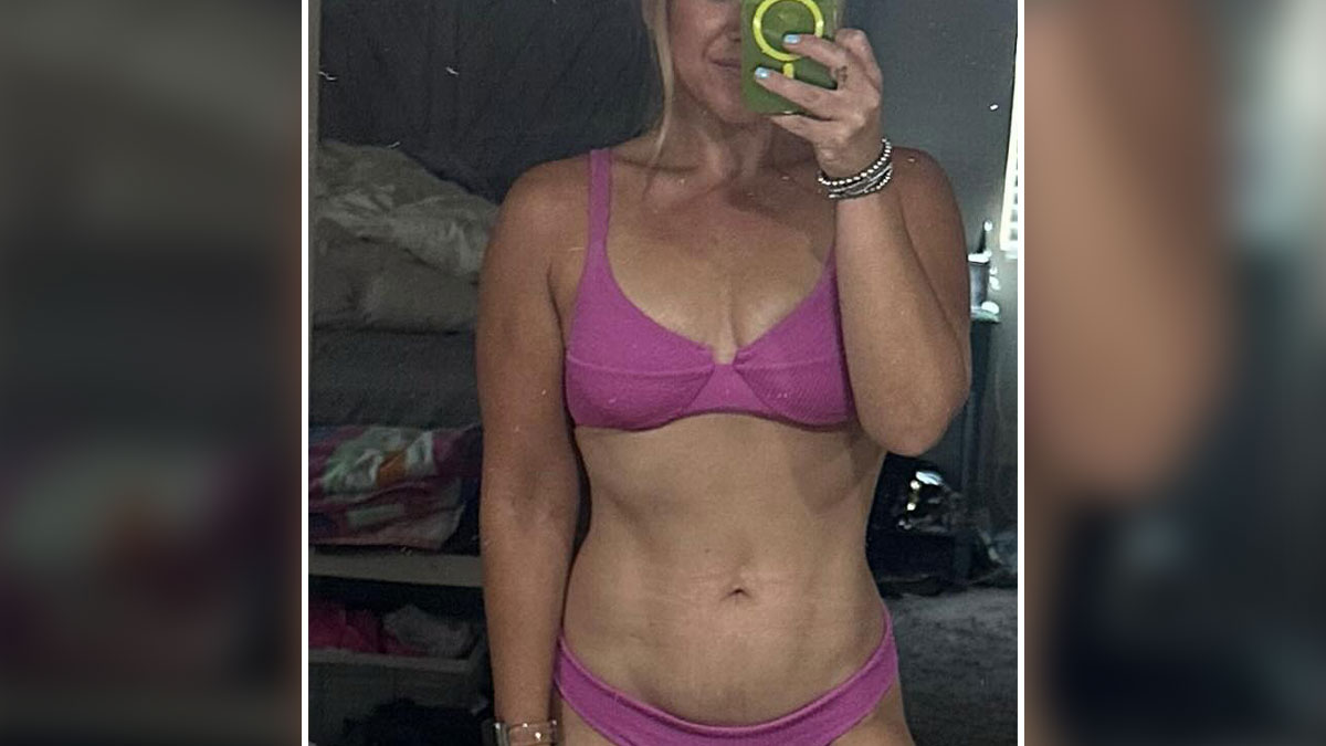 Fitness influencer taking mirror selfie in pink sports bra and underwear, highlighting weight loss and fitness journey controversy.