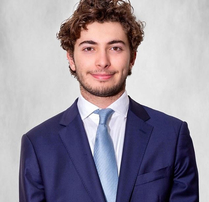 Young man in a suit with curly hair, capturing attention online related to Joe Biden's family Easter pic. Young man in a suit with curly hair, capturing attention online related to Joe Biden's family Easter pic.