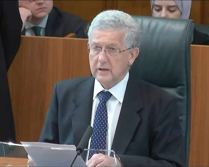 A person in a courtroom setting delivers a speech related to the Supreme Court's trans women decision. A person in a courtroom setting delivers a speech related to the Supreme Court's trans women decision.