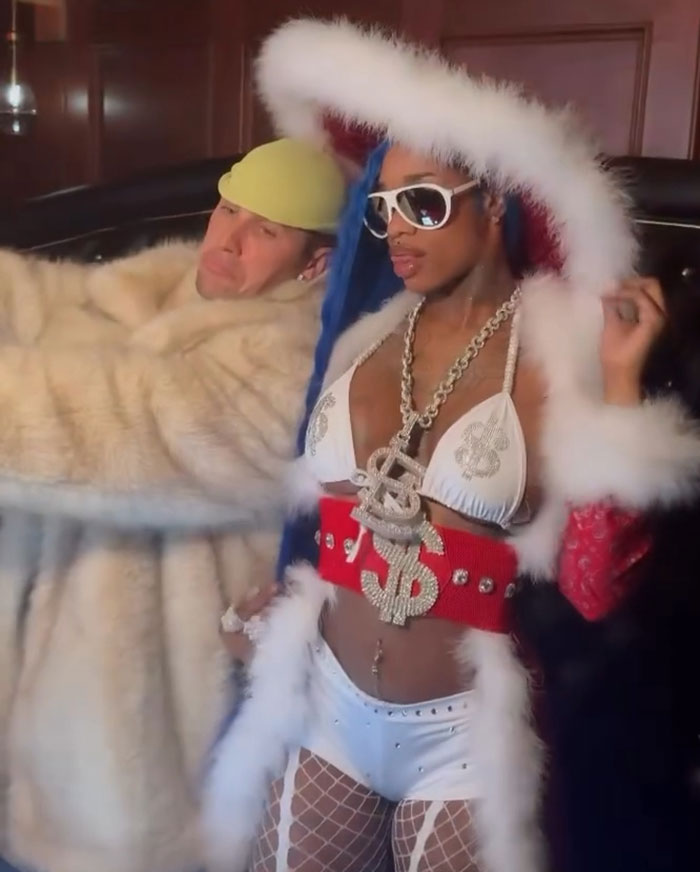 Justin Bieber dressed in a furry coat, standing beside a female rapper in a bold outfit, capturing attention. Justin Bieber dressed in a furry coat, standing beside a female rapper in a bold outfit, capturing attention.