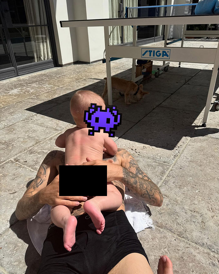 Baby by the pool with tattoos visible, creating online debate over photo privacy. Baby by the pool with tattoos visible, creating online debate over photo privacy.