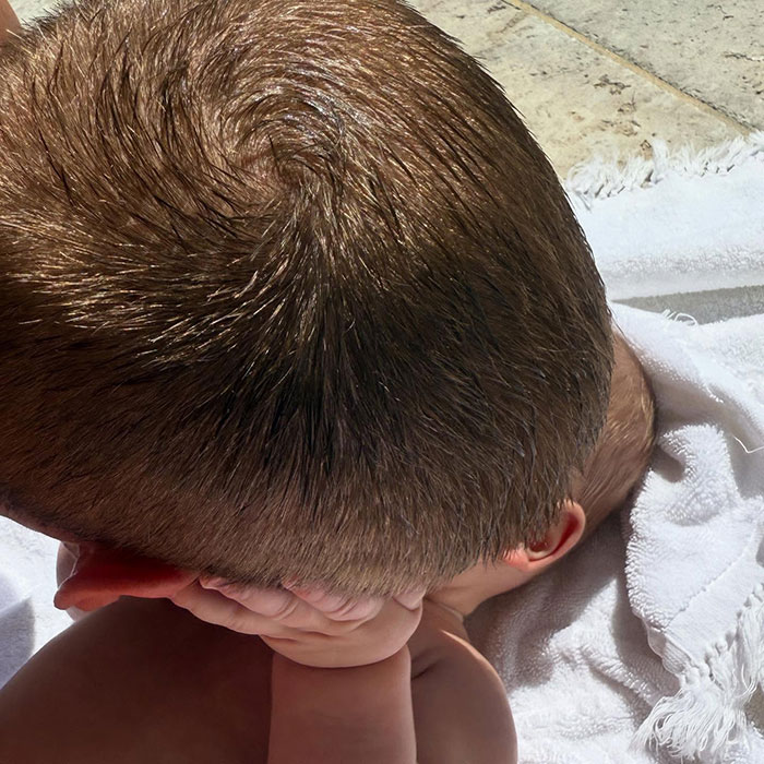 Baby by the poolside wrapped in a towel, with short hair exposed to sunlight, sparking internet debate. Baby by the poolside wrapped in a towel, with short hair exposed to sunlight, sparking internet debate.