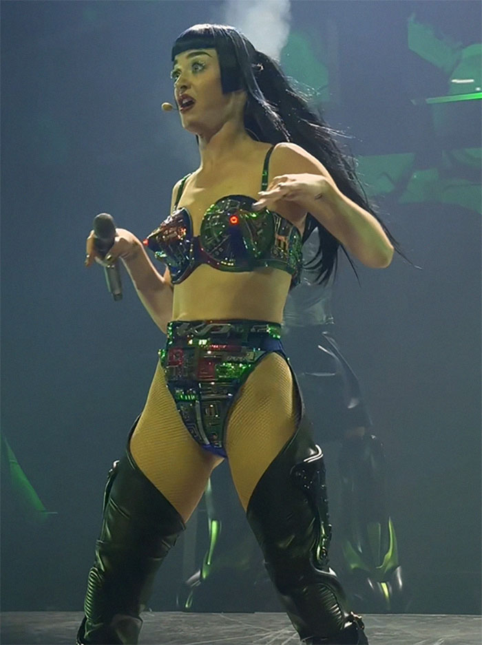 Singer performing on stage in futuristic outfit, captured during tour debut. Singer performing on stage in futuristic outfit, captured during tour debut.
