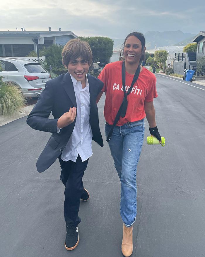 Two people walking happily on a suburban street, one in casual attire, promoting a supportive and joyful atmosphere. Two people walking happily on a suburban street, one in casual attire, promoting a supportive and joyful atmosphere.