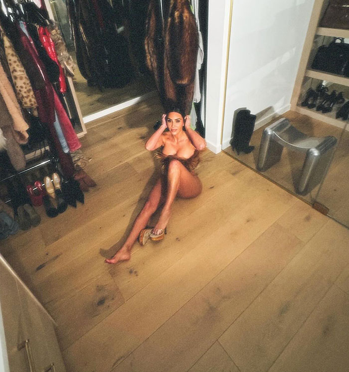 Person posing in a closet setting, sitting on the floor, with fashionable attire and heels, emphasizing glamour. Person posing in a closet setting, sitting on the floor, with fashionable attire and heels, emphasizing glamour.