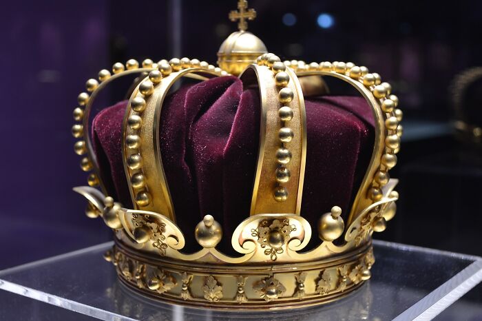 Golden royal crown with velvet cushion, representing monarchy. Golden royal crown with velvet cushion, representing monarchy.